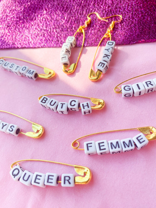 Gold safety pin word earrings