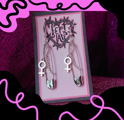 Safety pin earrings with Venus symbol charm