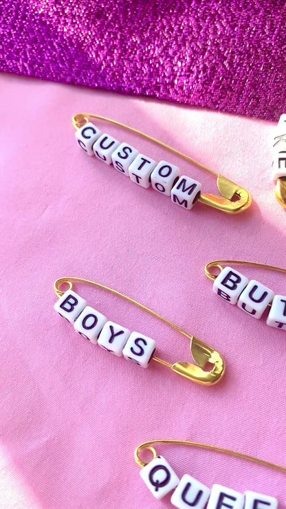 Gold safety pin word earrings