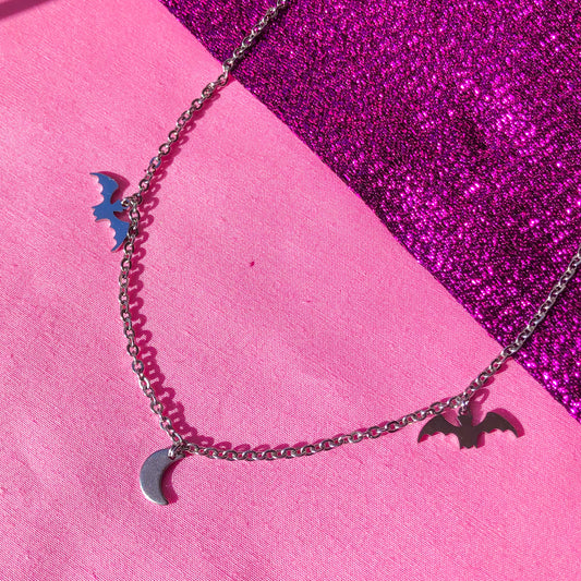 Dainty stainless steel necklace with three charms. The charms are a Bat, crescent moon and another bat.