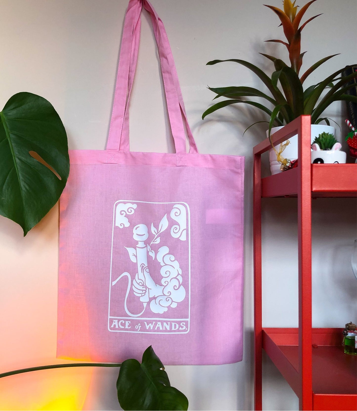 Pink tarot card tote bag with a white design. Original design based on Ace of Wands tarot card. A hand is coming out a cloud and holding a vibrator with the text ACE OF WANDS beneath