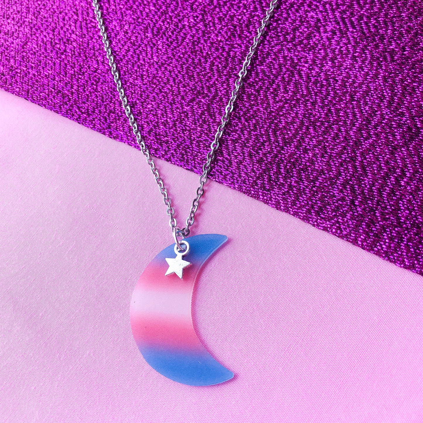 Transgender flag colours on a crescent moon charm attached to a stainless steel necklace chain