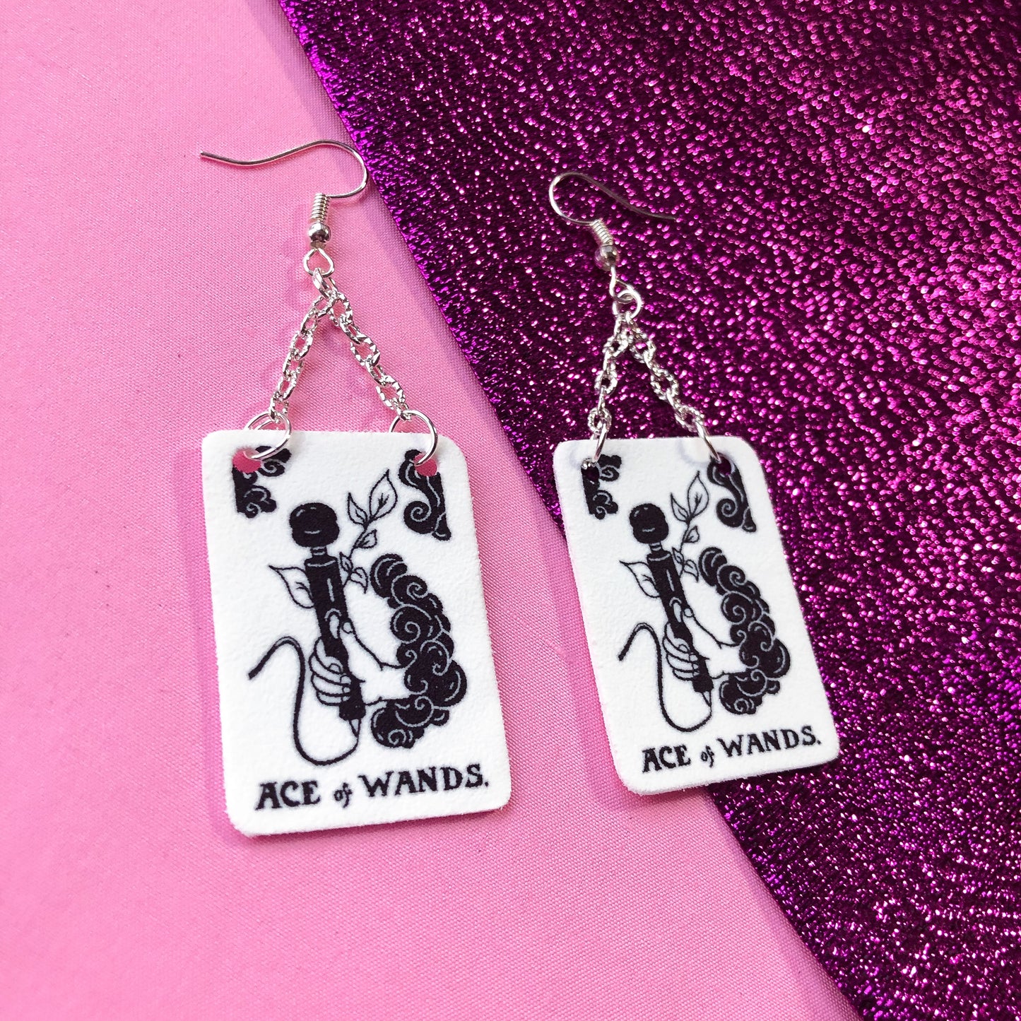 Black and white tarot card earrings. Original design based on Ace of Wands tarot card. A hand is coming out a cloud and holding a vibrator with the text ACE OF WANDS beneath